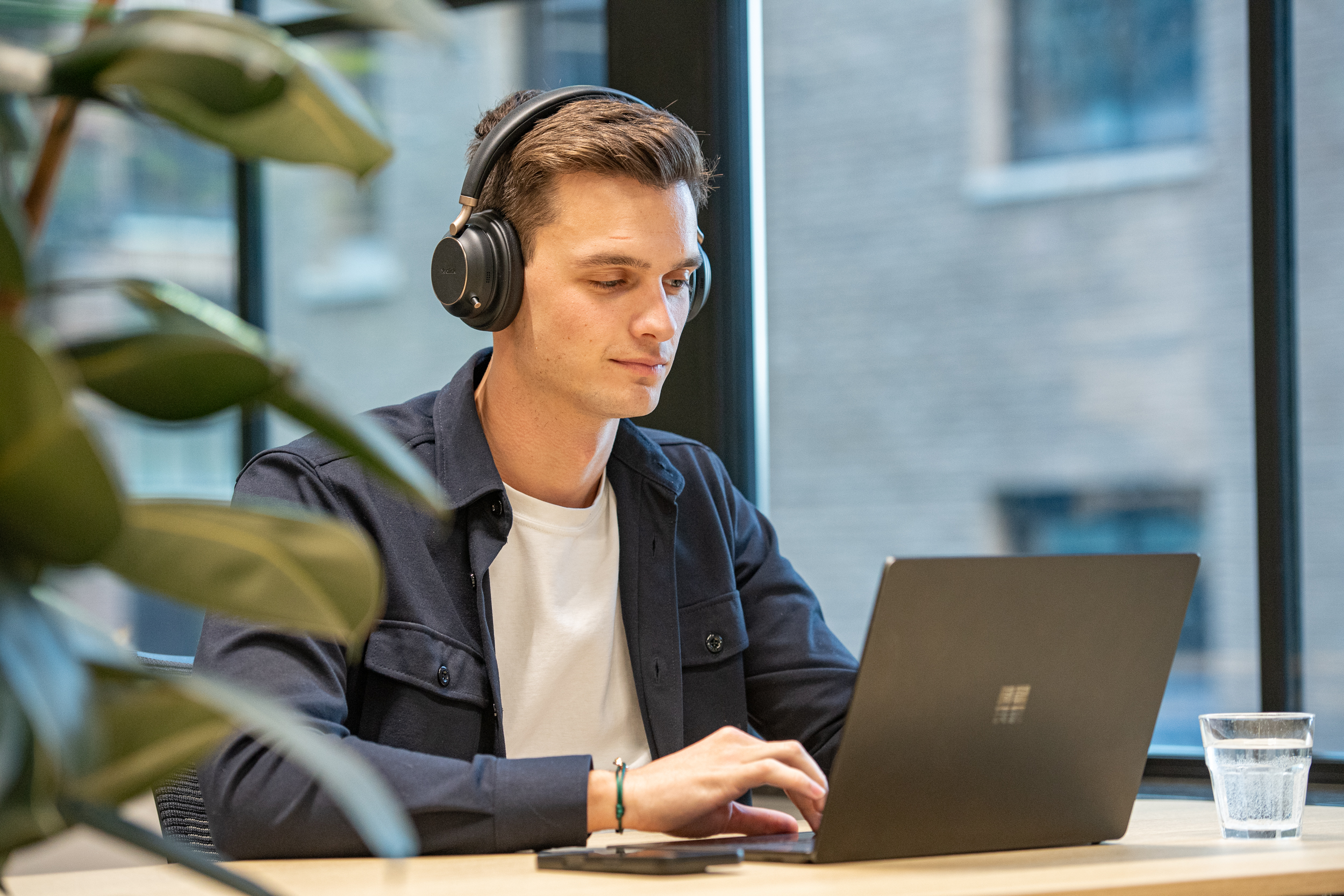 Divitel colleague working at a laptop with headphones